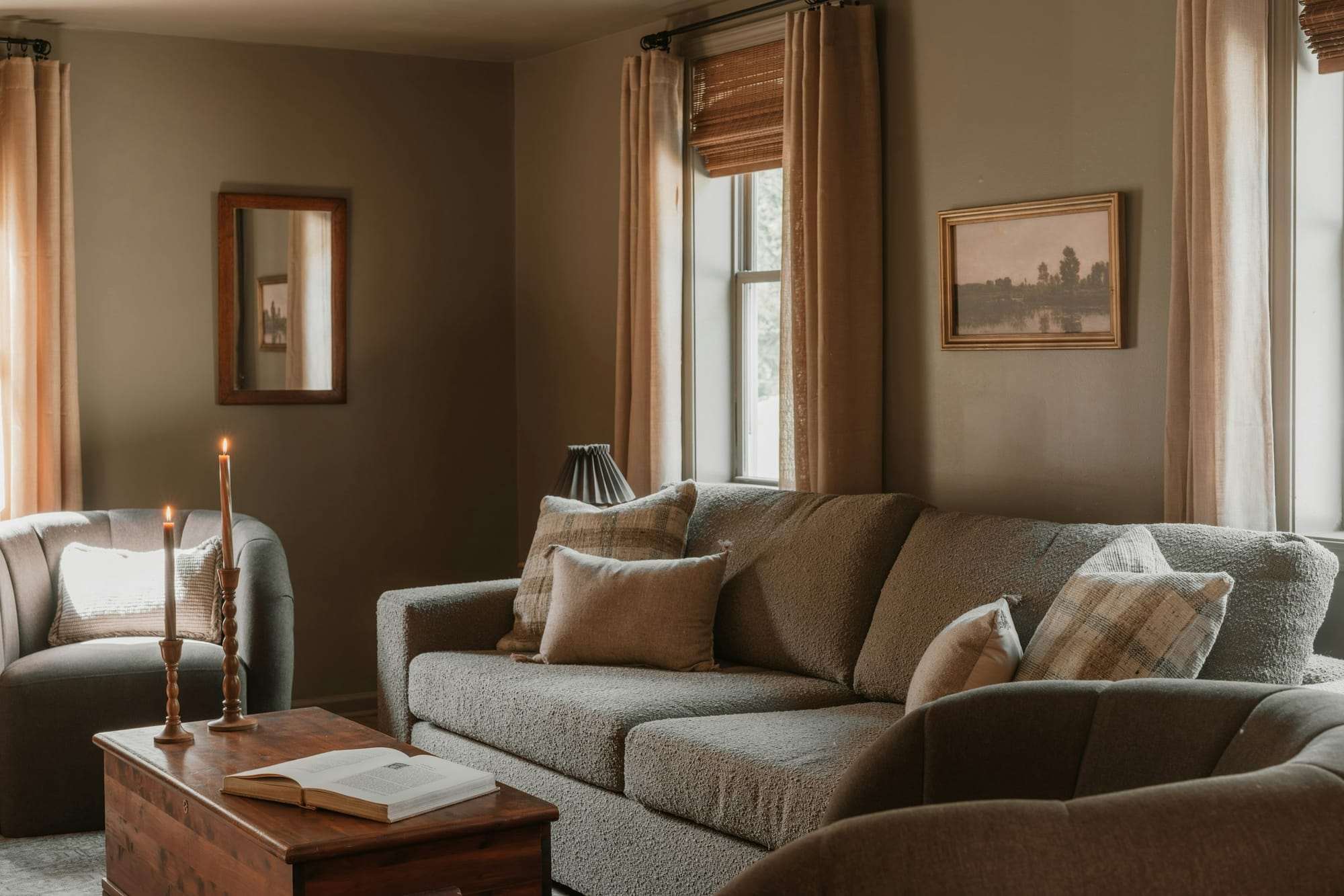 Sala de estar aconchegante, com sofá e candeeiros acesos
